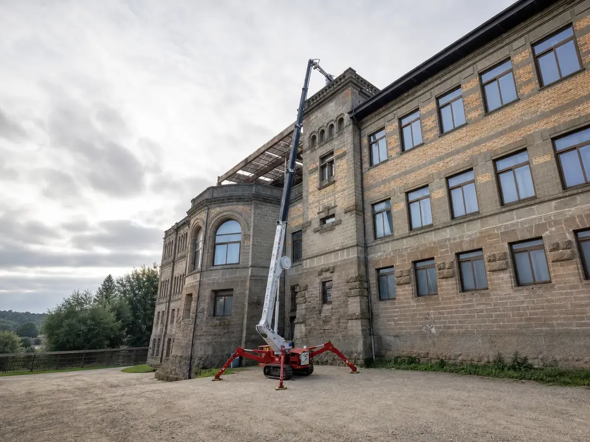 Piattaforma aerea a ragno al lavoro in quota sulla facciata di un palazzo storico